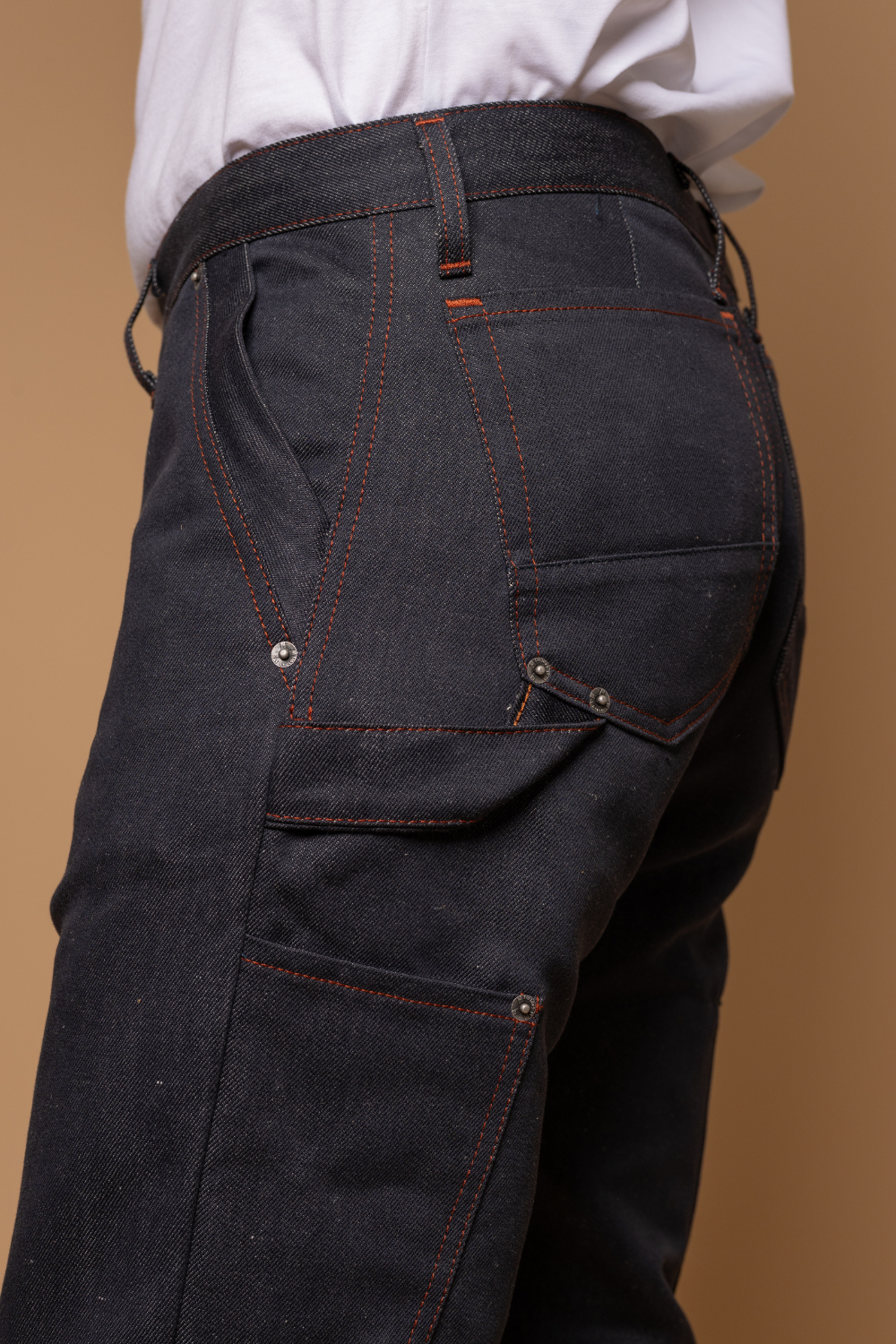 Plan rapproché du jeans en lin et coton bio Cargus à coupe droite cargo et taille mi-haute, de couleur bleu jeans, détail de la poche arrière et de la poche cargo, avec un t-shirt blanc, sur fond neutre - Le Gaulois jeans