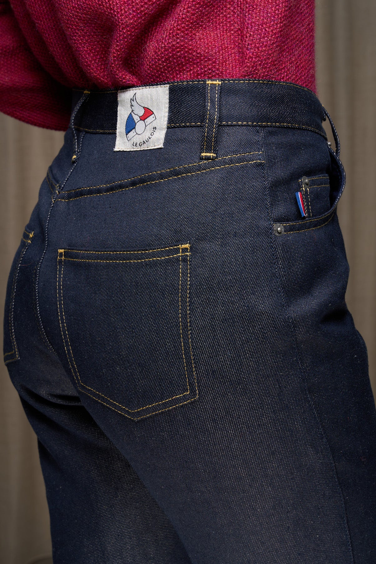 Jeans en lin pour femme Condate Bleu avec coupe droite taille mi-haute couleur bleu jeans, vue de trois quarts arrière montrant la texture en sergé, surpiqûres jaune et l'étiquette Le Gaulois jeans, sur fond neutre.