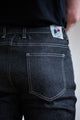 Jeans en lin et élasthanne recyclé modèle Divio Noir pour homme avec coupe près du corps, taille haute, couleur noir jeans, vue sur la poche arrière avec étiquette Le Gaulois jeans - tissage sergé croisé 2-en-1 à double retors, 380g/m2, fabriqué en France.