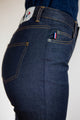 Vue de profil du jeans en lin Condate Bleu pour femme avec une coupe droite et taille mi-haute, couleur bleu jeans, montrant la texture du tissu sergé croisé non extensible et le détail de la fermeture à glissière, fabriqué en France - Le Gaulois jeans