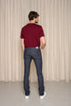 Homme de dos portant le jeans en lin et élasthanne recyclé modèle Divio Bleu avec une coupe près du corps, couleur bleu jeans, taille haute, sur fond de rideau beige - Le Gaulois jeans