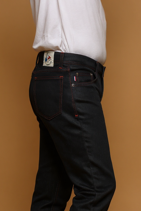 Plan rapproché du jeans en lin et coton bio Ruscino à coupe droite et taille mi-haute, de couleur bleu jeans, détail de la poche arrière et étiquette de la marque, avec un t-shirt blanc, sur fond neutre - Le Gaulois jeans