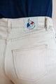 Jeans en lin Lutèce en Lin Naturel couleur ivoire avec une coupe Mom, taille haute et étroite aux chevilles, vue de la poche arrière avec étiquette Le Gaulois, fabriqué en France avec lin de Normandie, sur fond uni.