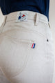 Jeans en lin Nicia en Lin Naturel affichant une couleur naturelle ivoire sans teinture, coupe près du corps et taille haute avec un tissage sergé croisé, étiquette Le Gaulois et petit drapeau français sur la poche arrière droite, fabriqué en France.