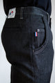 Modèle homme de dos portant le jeans en lin Lugdunum Noir à coupe chino, couleur noire avec fermeture à glissière et étiquette Le Gaulois jeans, mettant en avant la qualité du tissu et la finition avec un drapeau français sur la poche arrière.