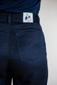 Vue de près sur le jeans en lin modèle Condate Bleu pour femme avec coupe droite mi-haute, montrant la texture du tissu sergé croisé, la couleur bleu jeans et l'étiquette Le Gaulois sur la poche arrière droite - fabriqué en France.