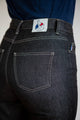 Vue de dos d'une femme portant le jeans en lin Condate Noir jeans avec une coupe droite et taille mi-haute, mettant en valeur le tissu de qualité et la poche arrière cousue, étiquette Le Gaulois jeans apparente.